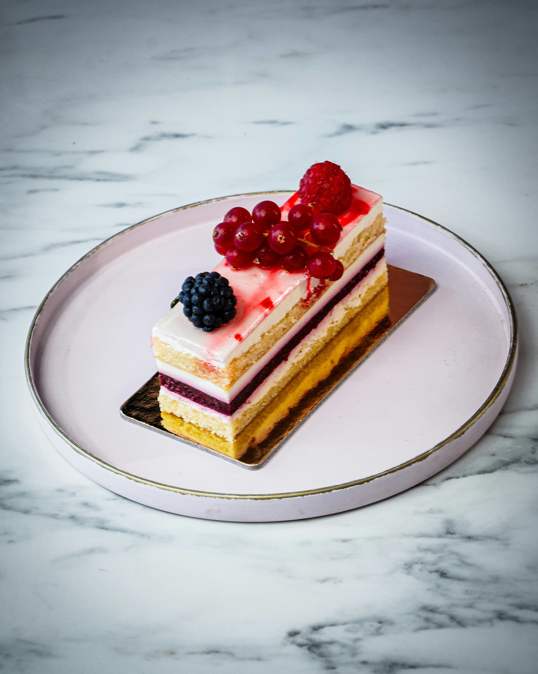 Elegant layered cake decorated with freeze-dried raspberries in a commercial bakery